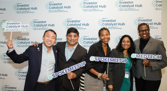 A Spoke Member’s Guide to Network Engagement; group photo of attendees at a spoke networking event, holding signs that say #SpokeMeetup and Investor Catalyst Hub