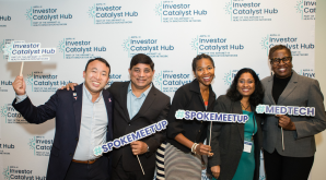 A group photo of people holding up #SPOKENETWORK hashtag signs at an ARPA-H Investor Catalyst Hub event